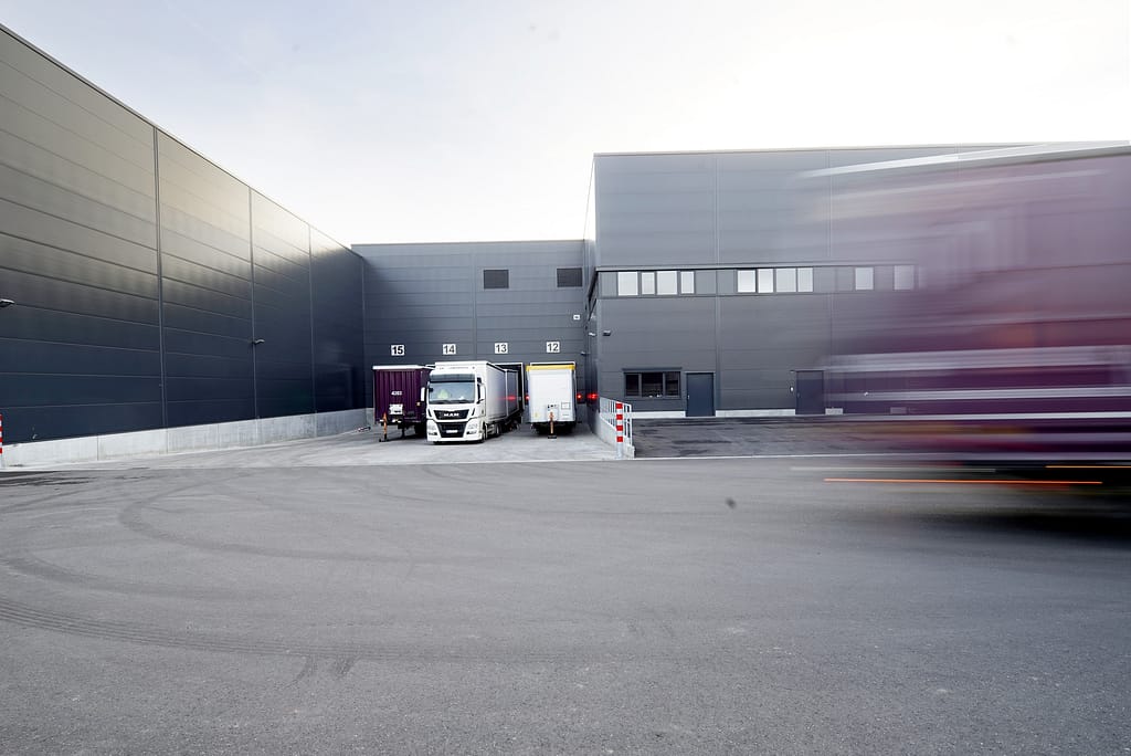 Foto einer Logistikhalle mit  Lkw vor den Rampen