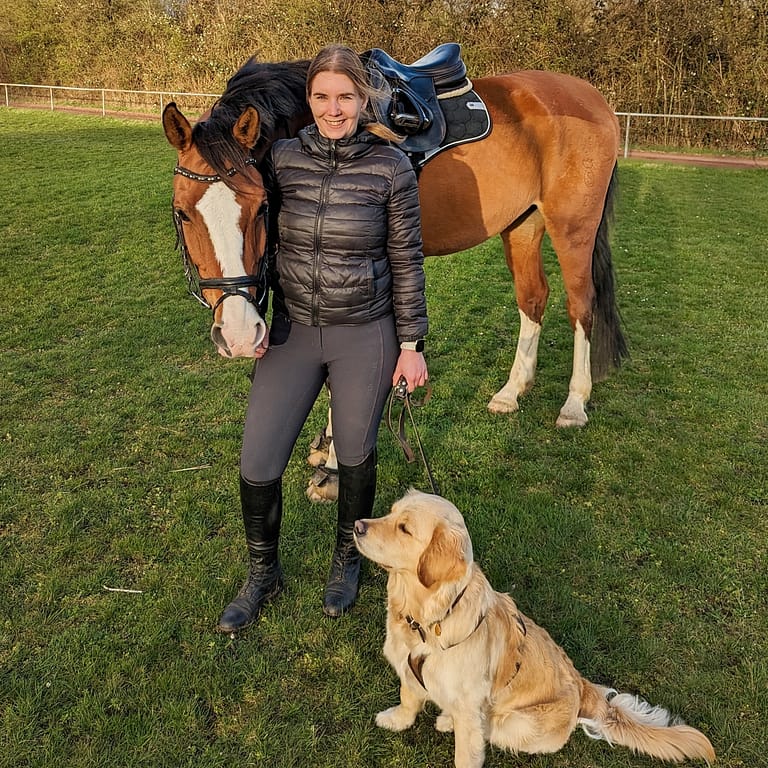 Aurelistin Anke Eisenburger mit Pferd und Hund auf einer grünen Wiese